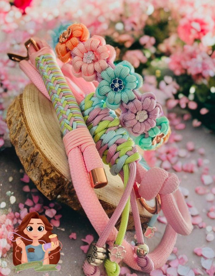 L'image présente une collection vibrante de colliers pour chiens colorés, aux motifs variés. Ces accessoires faits main intègrent des éléments floraux, notamment des roses et d'autres fleurs, principalement dans des tons roses.