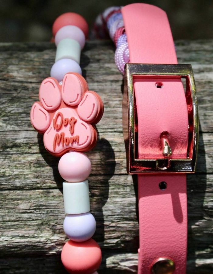 L'image présente un collier rose et un collier de perles roses, tous deux posés sur une surface en bois. Elle met en valeur les accessoires de mode et évoque l'ambiance nature. Les colliers pour chiens sont ludiques et colorés, adaptés à diverses occasions et styles.
